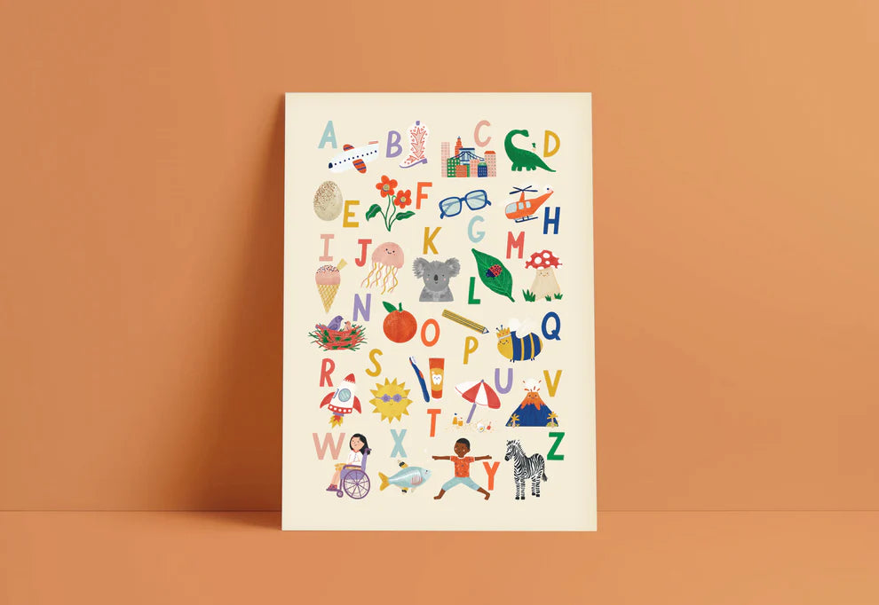 Framed children's alphabet poster by Lauren Sissons with colorful illustrations corresponding to each letter, including animals, objects, and playful scenes on a beige background.