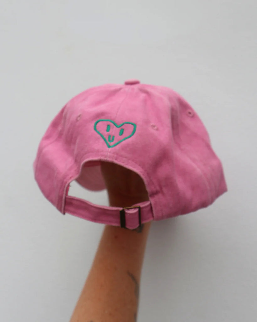 Back view of the pink adults "Heart Full" cap showing a sweet embroidered heart and adjustable strap, offering a comfy fit with thoughtful detail.