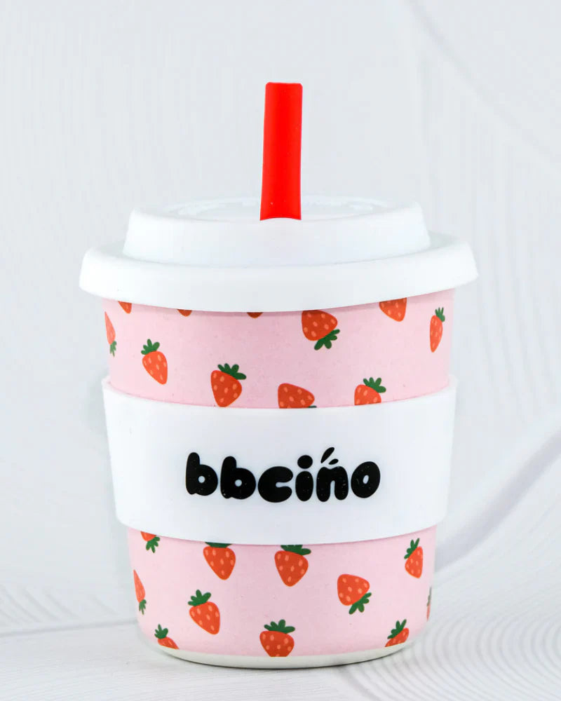 BBCino BambinoCino 240ml reusable cup in pink featuring strawberries, made from sustainable bamboo. Lightweight, durable, with a rounded base to prevent tipping, perfect for hot or cold drinks.