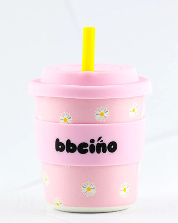 BBCino BambinoCino 240ml reusable cup in baby pink with a daisy design, made from sustainable bamboo. Lightweight, durable, with a rounded base to prevent tipping, perfect for hot or cold drinks.