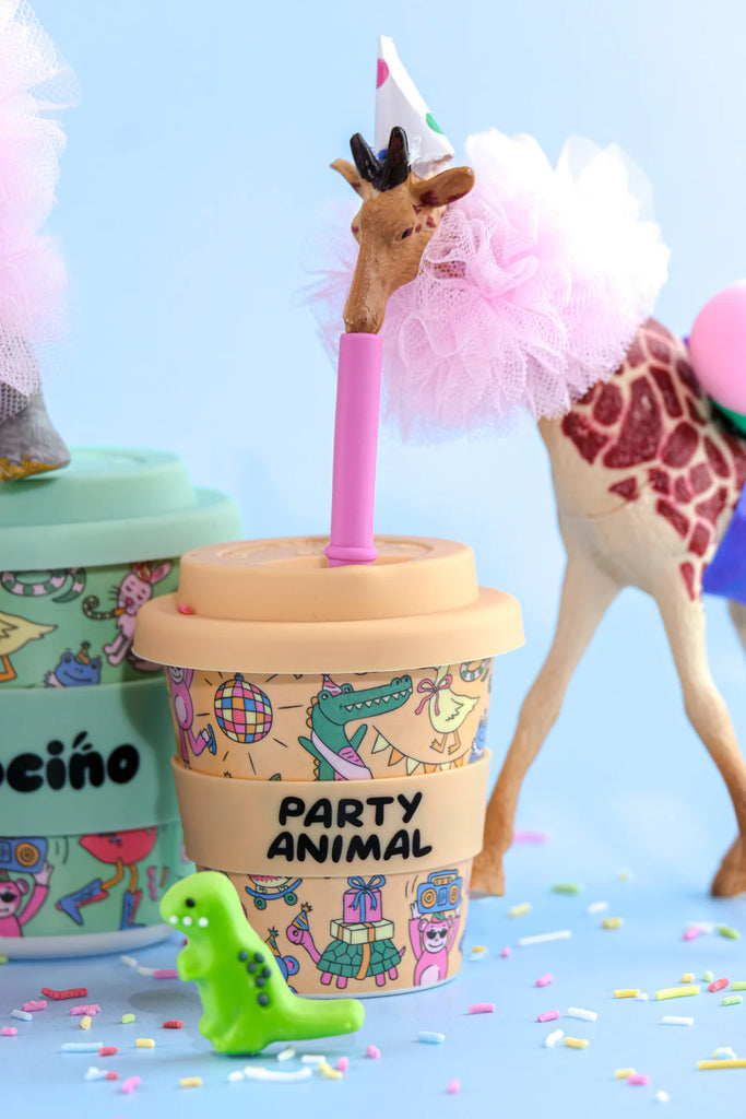 BBCino reusable bamboo cup 120ml in Party Animal orange print, styled with toy giraffe, dinosaur and sprinkles, eco-friendly kids party cup.
