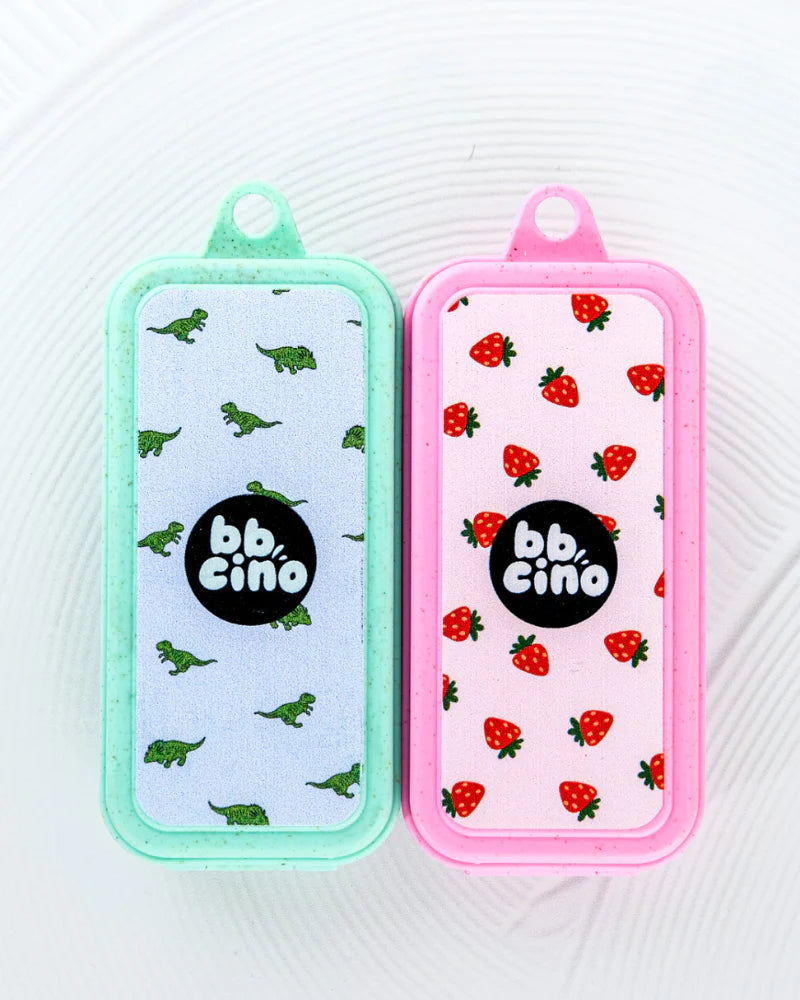Two BBCino eco-friendly straw cases, one with a dinosaur print and one with a heart print, displayed side by side.