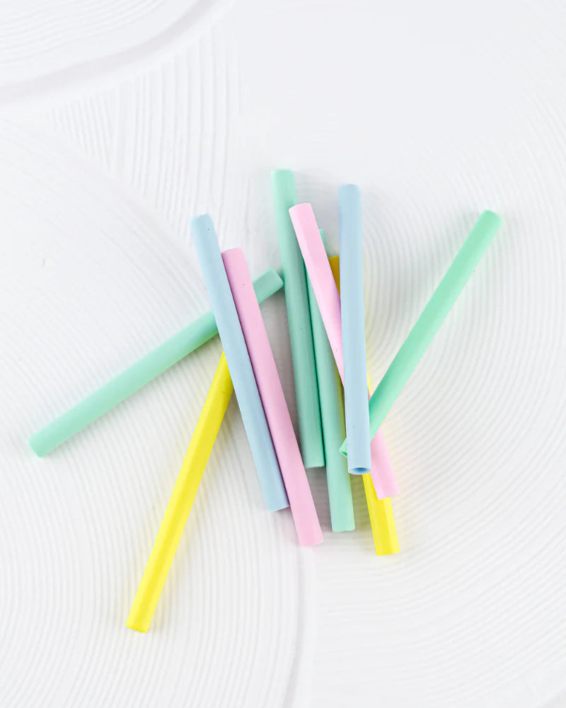 BBCino colourful silicone straws made from food-safe, BPA-free silicone spread out on a white background.