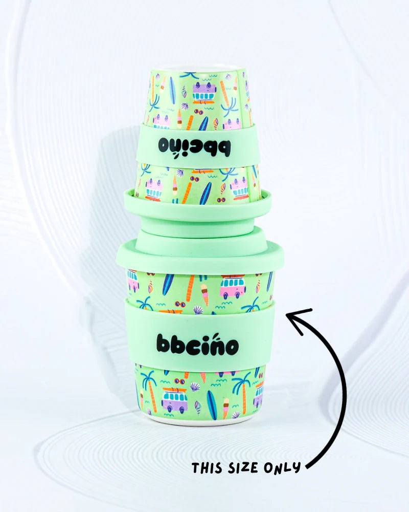 Bbcino 240ml reusable cup pictured with the 120ml cup (for size comparison) both with beach design on mint green background,with mint green lid and navy coloured straw. 