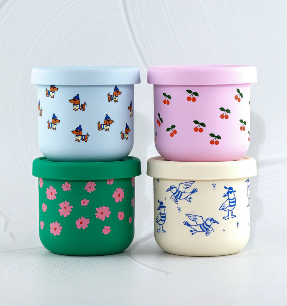 Stack of BBCino silicone snack pots in multiple designs including Chippie Crew seagull print, reusable eco-friendly containers safe for freezer and microwave.