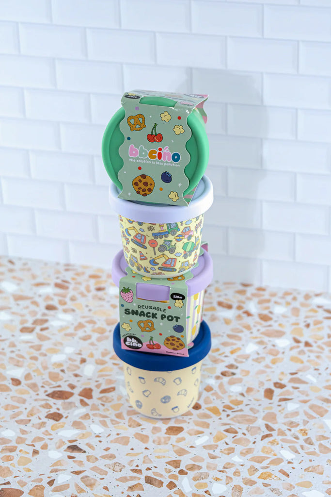 Stack of BBCino reusable bamboo snack pots in various designs including Daisy BB daisy print, sustainable eco-friendly containers with silicone lids.