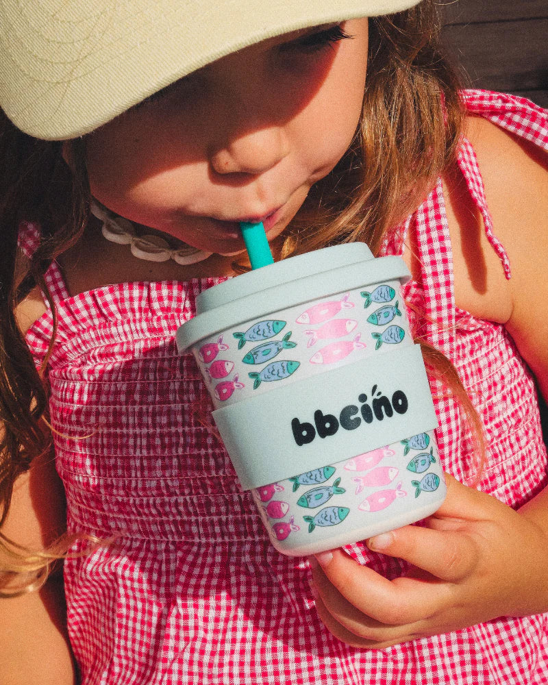 Child in gingham outfit drinking out of the BBCino Ashleigh Fish cup.
