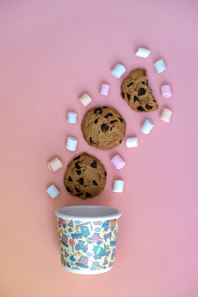 BBCino reusable bamboo snack pot in Dig It design, styled with cookies and mini marshmallows on pink background, sustainable kids snack container.