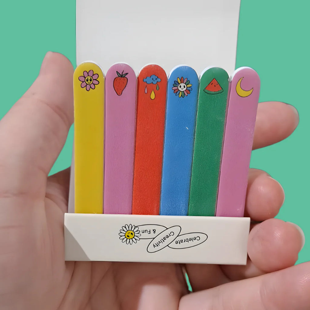 Hand holding a colorful set of Hanami Mini Nail Files featuring fun icons like a flower, strawberry, and moon.