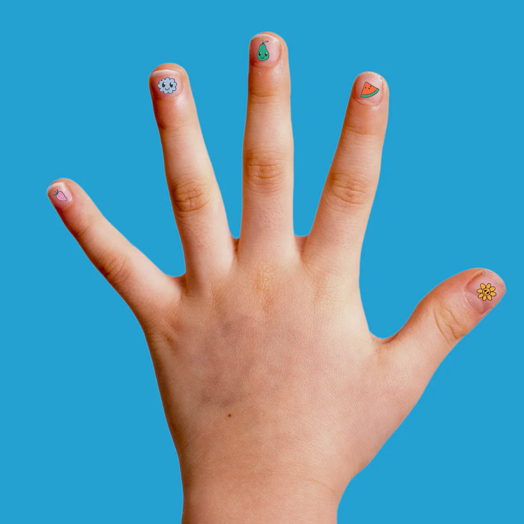 Child’s hand with Buds fruit nail stickers applied, showing designs like watermelon, pear, flower, and strawberry on each fingernail.