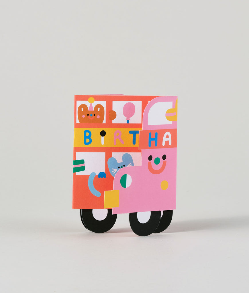 Birthday bus card completely folded flat, showing the illustrated back of the bus with playful details and colourful design.