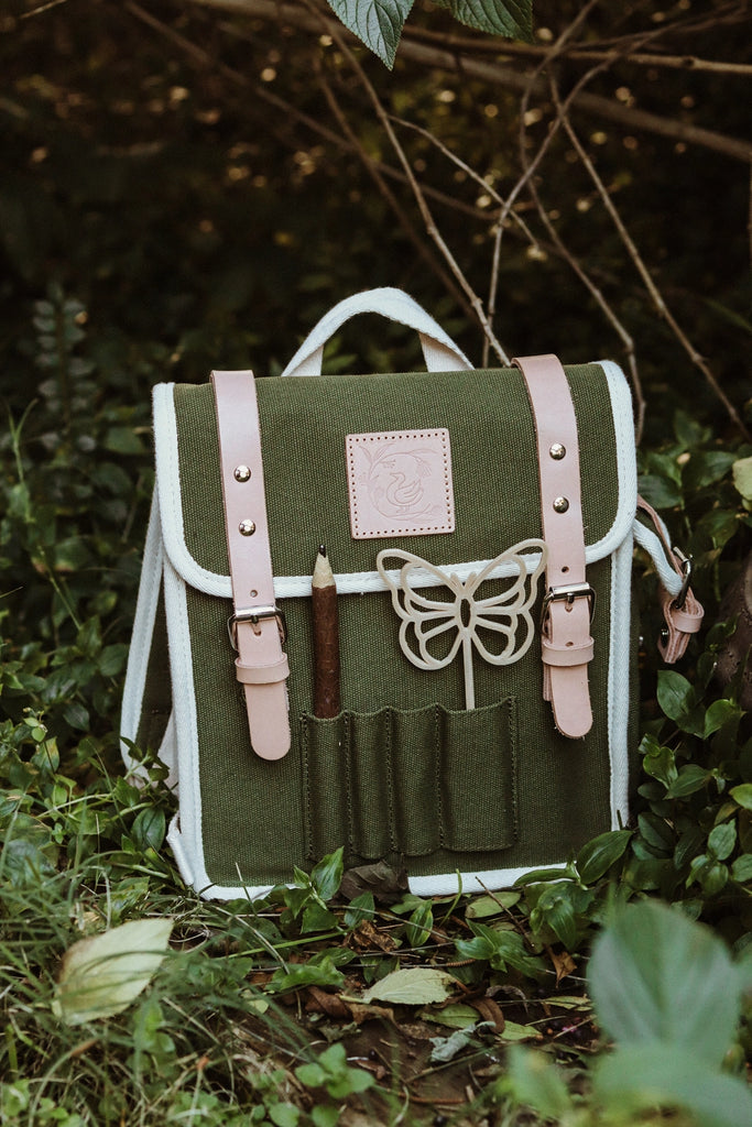 Butterfly-shaped bubble wand resting in green backpack, designed for kids’ eco-friendly play.
