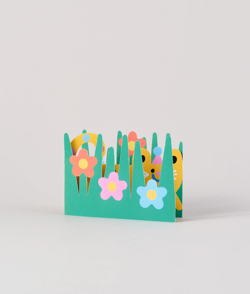 Back view of the fold-out cat card with green and yellow floral pattern, folded slightly to display its three-dimensional shape.