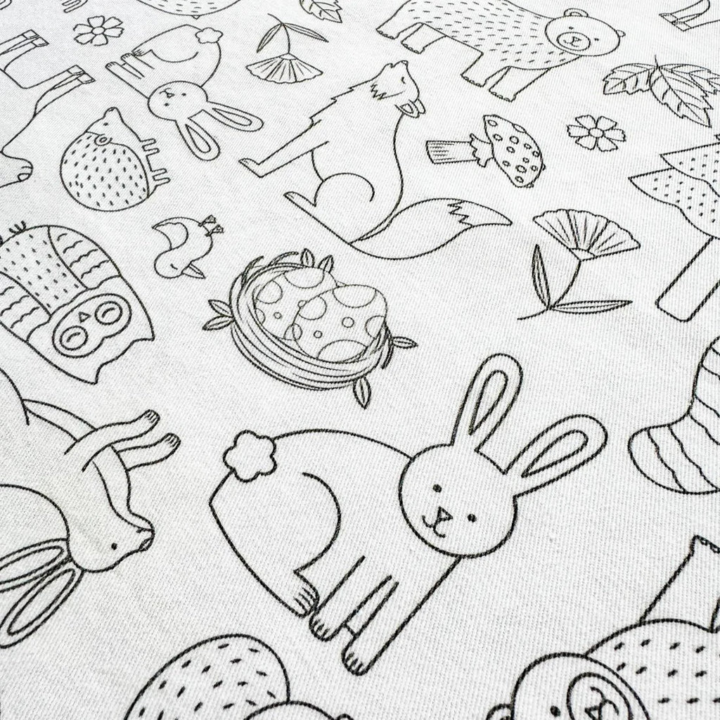 Close-up of the Woodland Wonders reusable colouring-in tablecloth featuring forest animals like rabbits, owls, and hedgehogs in black-and-white outlines.