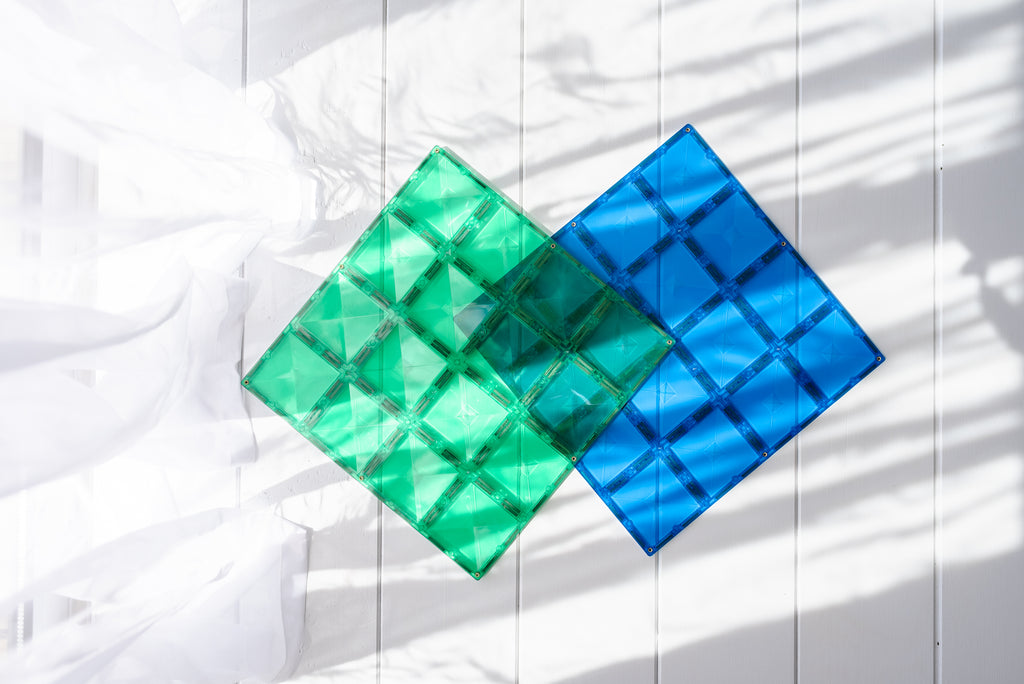 Flat lay of both base plates placed on a white fabric surface with window shadows, showcasing colour contrast and texture.