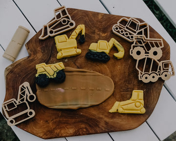 Decorative set of construction-themed cutters on a wooden board.