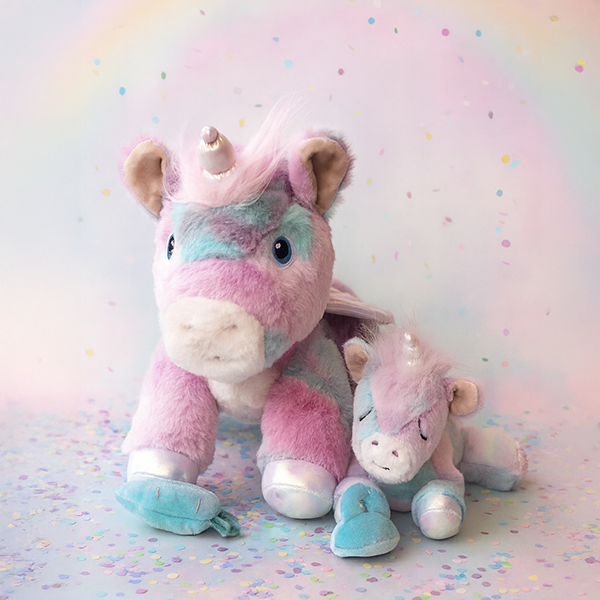 Dazzle unicorn and baby unicorn plush together – Rainbow pastel unicorn with smaller unicorn companion on a soft confetti background.