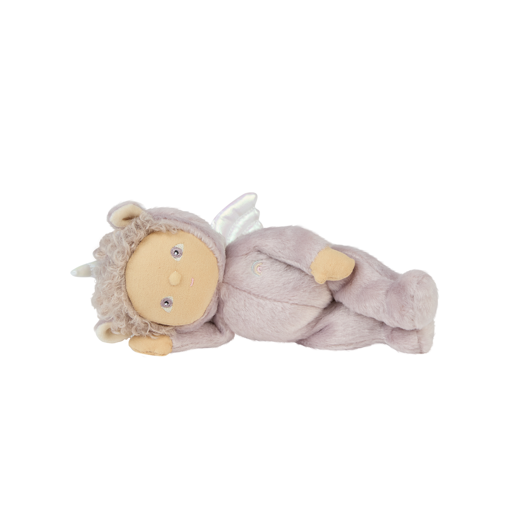 Uma Unicorn lying down – Soft lilac plush unicorn doll posed for nap time, showing delicate embroidered eyelashes.