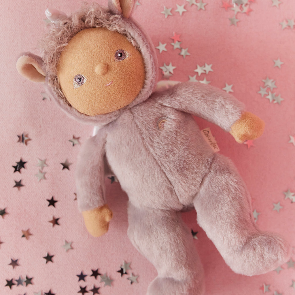 Close-up of Uma Unicorn on pink background with star confetti – Lilac unicorn doll surrounded by metallic star decorations.