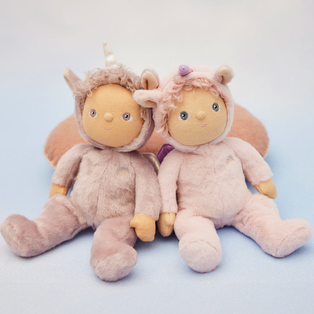 Pair of Dinky Dinkum unicorn dolls on light blue background – Uma Unicorn and Una Unicorn sitting side-by-side, smiling softly.