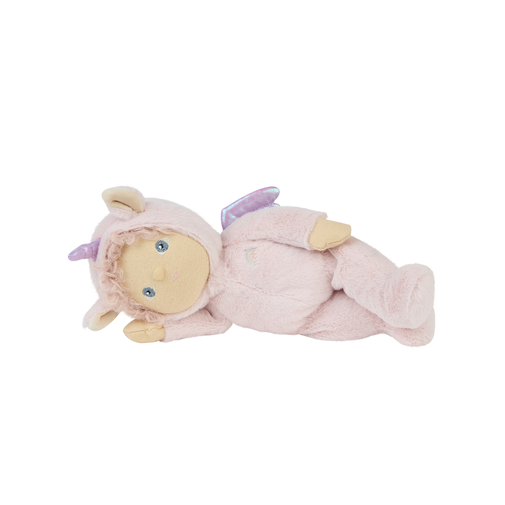 Side view of Una Unicorn lying down – wearing pink unicorn outfit with embroidered details and plush limbs.