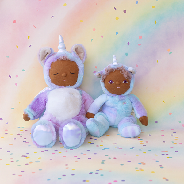 Uli and another Dinkum Unicorn Doll together – Pair of pastel unicorn dolls sitting side by side on a confetti rainbow backdrop.