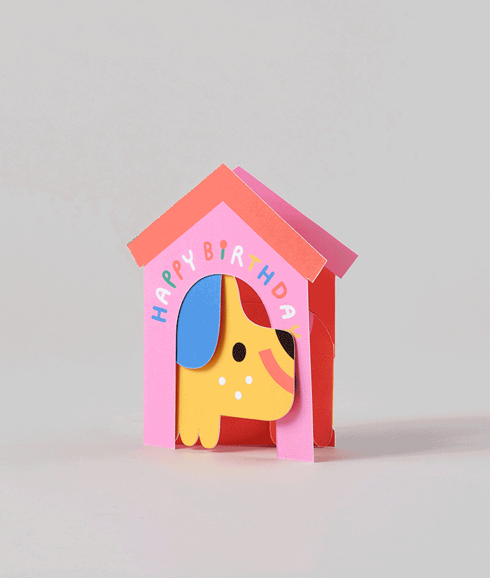 Side angle of dog in house fold-out card, showing the yellow dog figure extending from the pink and red doghouse.
