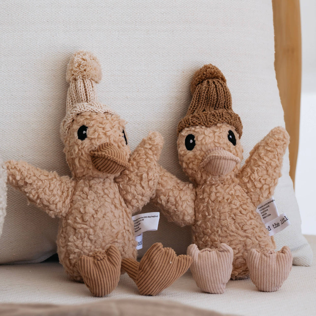 Side-by-side plush toys—Edmond Duck and Petunia Duck—displaying their cotton plush bodies, corduroy details, and knitted beanies in soft pastel tones.