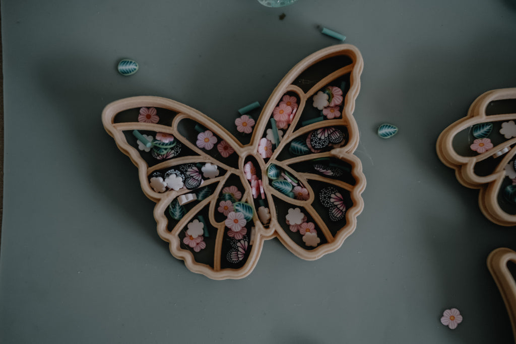 Biodegradable playdough cutters shaped like fairy garden characters, laid out for a magical play scene.
