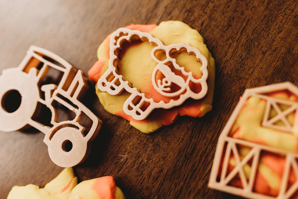 Close-up of sheep, tractor and barn cutters made from recycled sawdust and PLA, perfect for small hands and sensory play.