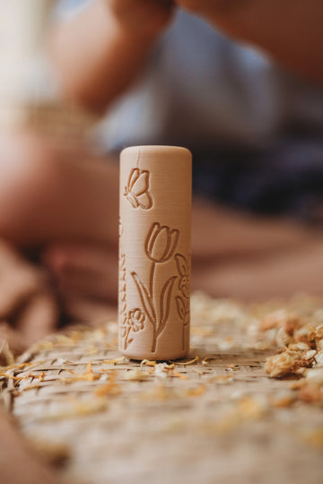 Close-up of Kinfolk Pantry Flower Playdough Roller standing upright on wooden surface, showing engraved floral pattern and eco-friendly texture.