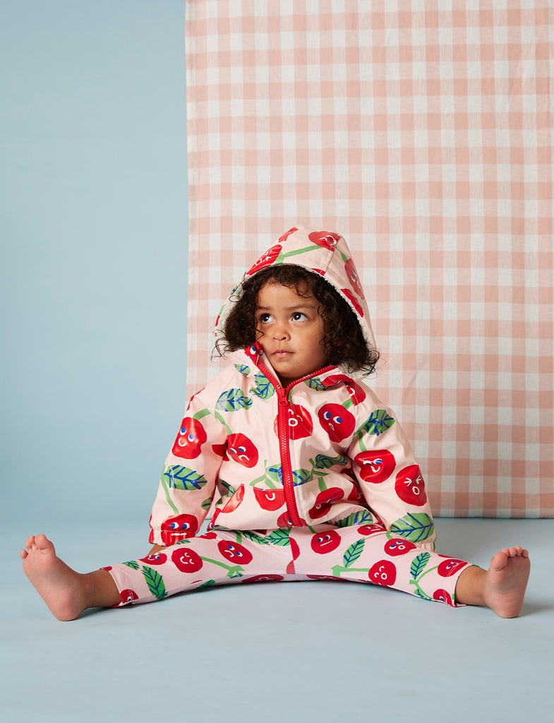 Front view of toddler in Cheeky Cherry baby leggings by Halcyon Nights, with a playful cherry print and comfy elastic waist for everyday wear.