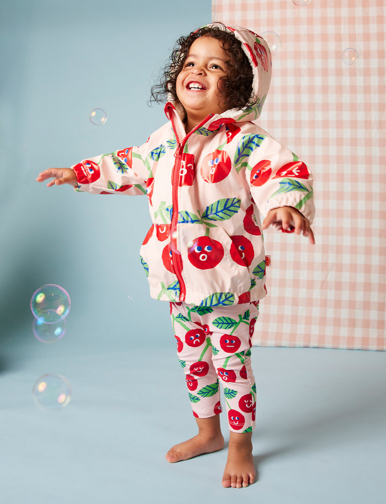 Toddler standing and playing in Cheeky Cherry leggings and top, highlighting freedom of movement, vibrant print, and fun outfit styling.
