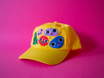 Cheerful yellow cotton twill cap, the Happy Chap Cap, designed by Melbourne illustrator Samantha Curcio. Features playful embroidered details, perfect for kids aged 2+.