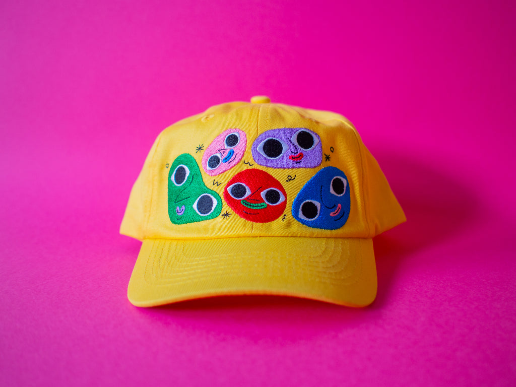 Cheerful yellow cotton twill cap, the Happy Chap Cap, designed by Melbourne illustrator Samantha Curcio. Features playful embroidered details, perfect for kids aged 2+.