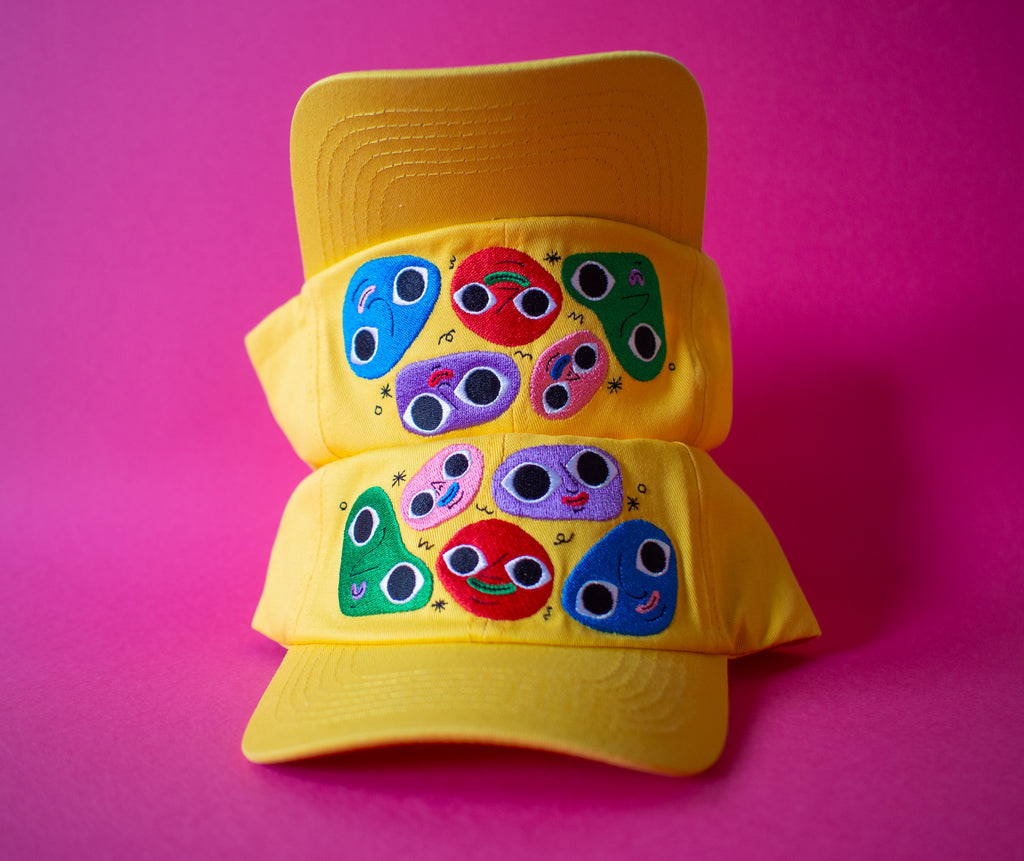 Cheerful yellow cotton twill cap, the Happy Chap Cap, designed by Melbourne illustrator Samantha Curcio. Features playful embroidered details, perfect for kids aged 2+.