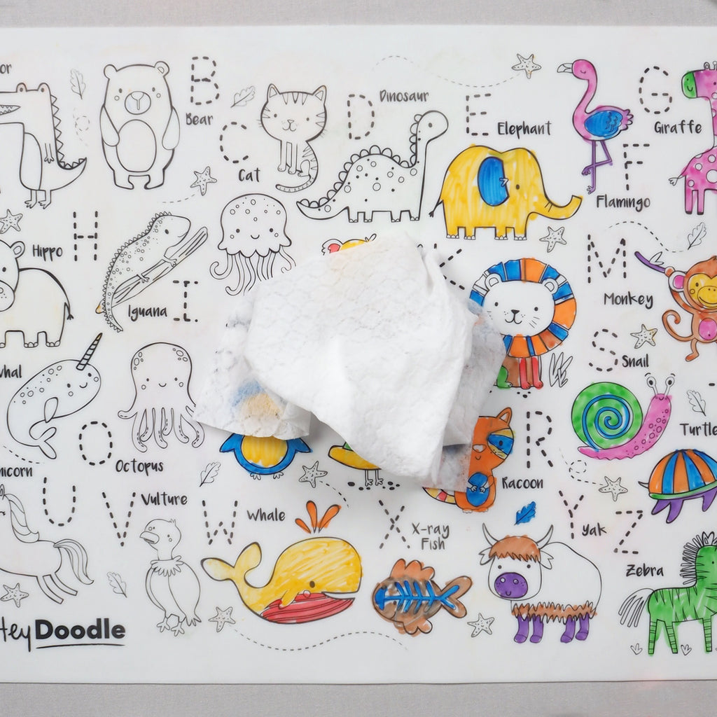 HeyDoodle Into the Wild mat displayed half cleaned with wip and half coloured in, showing interactive alphabet-themed animal illustrations.