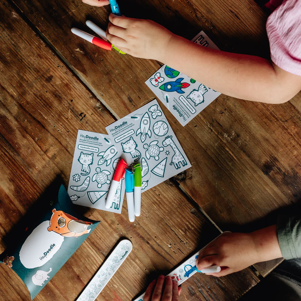 Multiple children using HeyDoodle Sketchband kits at a party table, engaging in creative play.