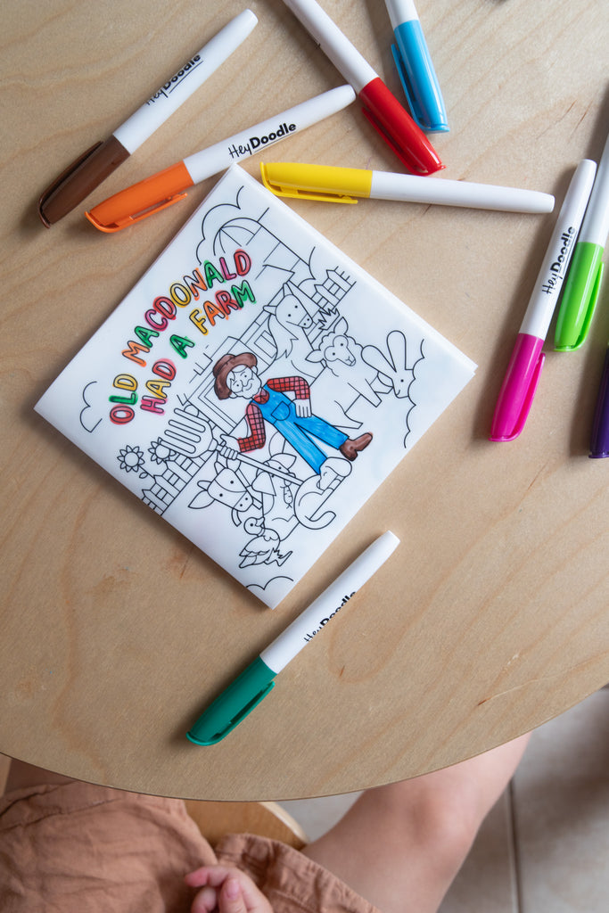 Child colouring the HeyDoodle Old MacDonald reusable silicone book with included markers.