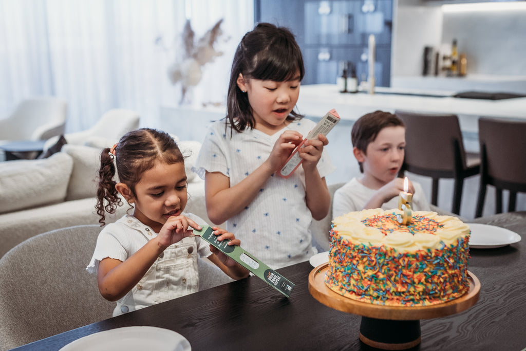 Three children enjoying a party while decorating their Toot Toot Honk Sketchbands as party favours.