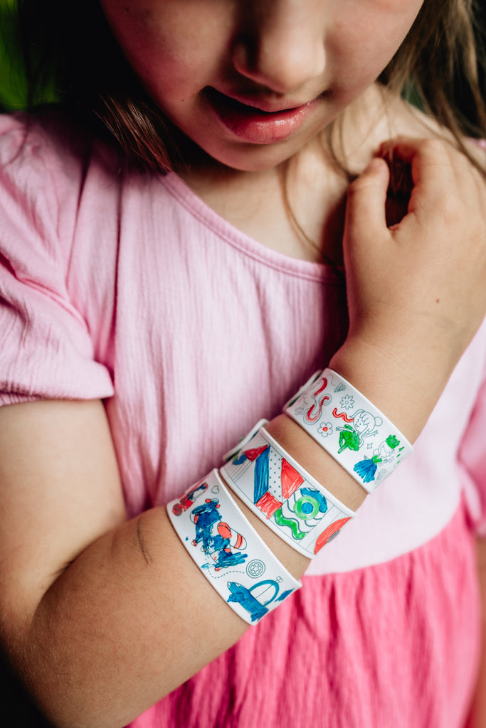 Child proudly wearing their coloured HeyDoodle slap bracelets on their wrist.