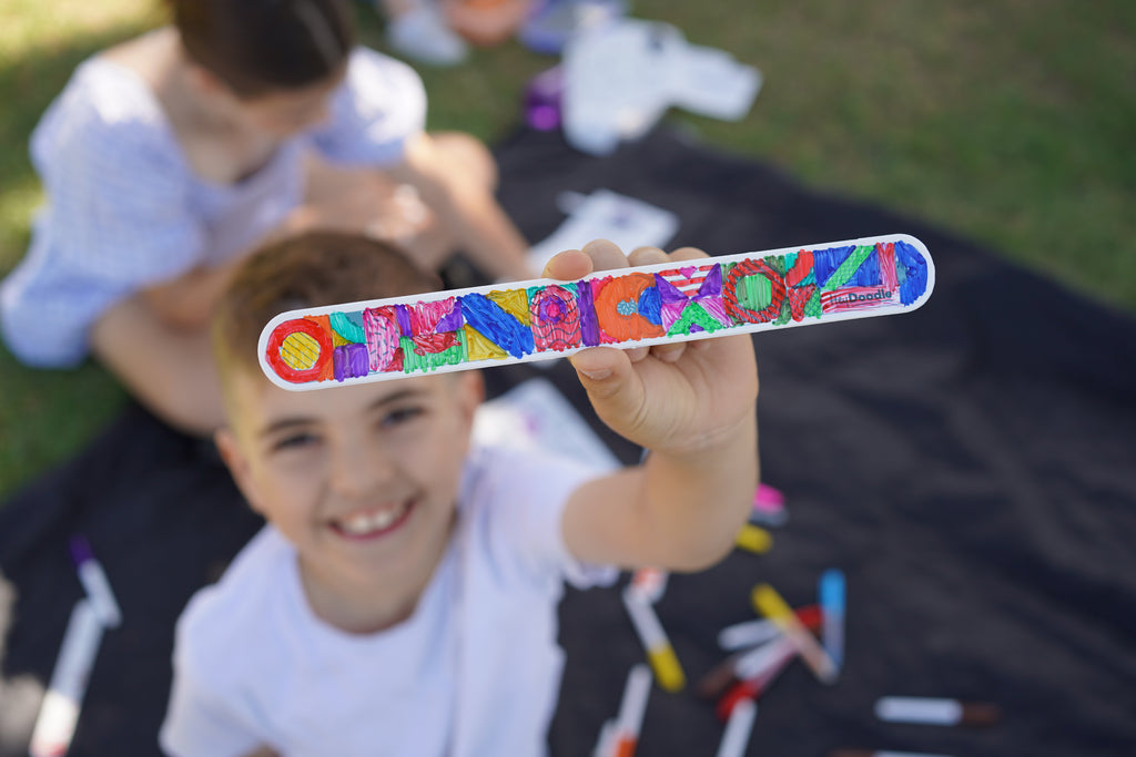 Kids playing outdoors while showing off their reusable HeyDoodle Sketchbands.