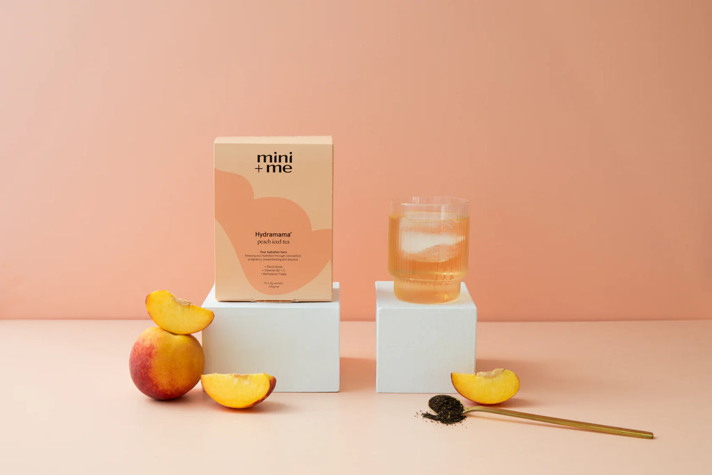 Hydramama Peach Iced Tea Hydration Electrolyte Drink for Pregnancy & Postpartum - Box displayed with drink and fresh peaches
