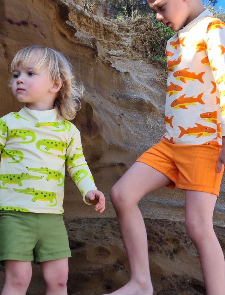 Vibrant crocodile-print rash shirt with UPF 50+ protection, a high neck for extra sun coverage, and a zip-free comfy fit. Perfect for bold, sun-safe water adventures.
