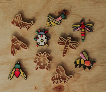 Biodegradable insect-themed dough cutters styled with natural playdough and bug figurines.