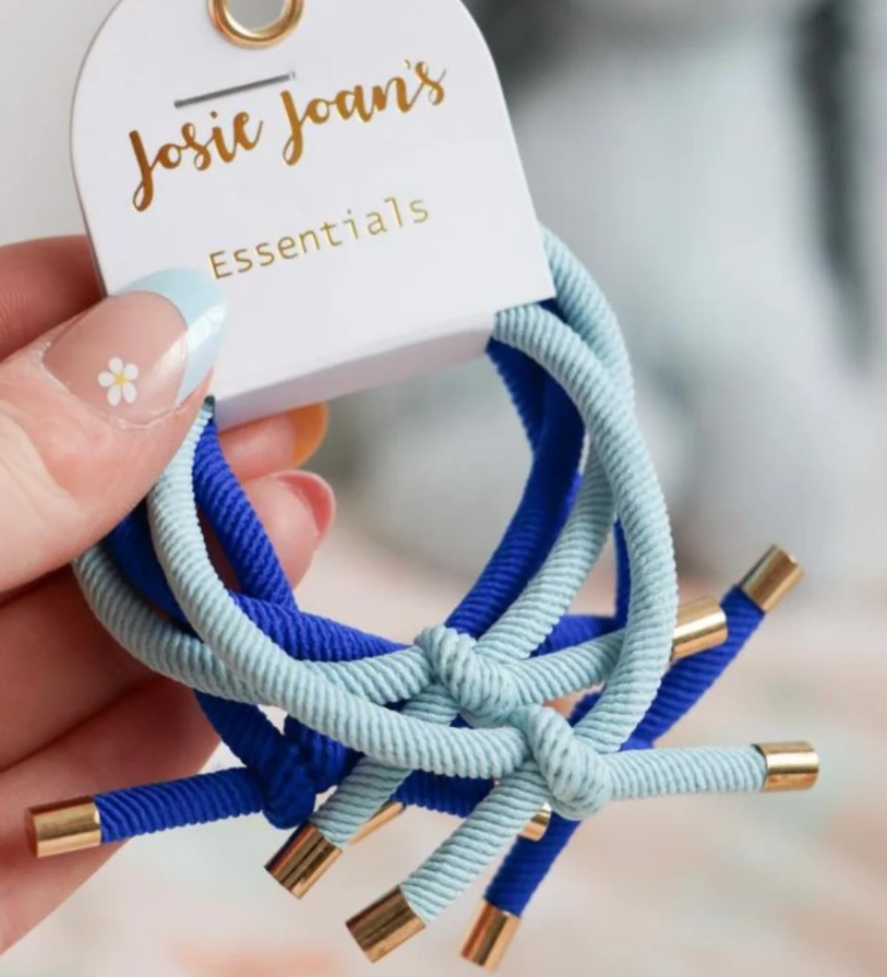 A set of 5 blue hair ties with gold details, presented on a card with ' Josie Joans Essentials ' written on it.