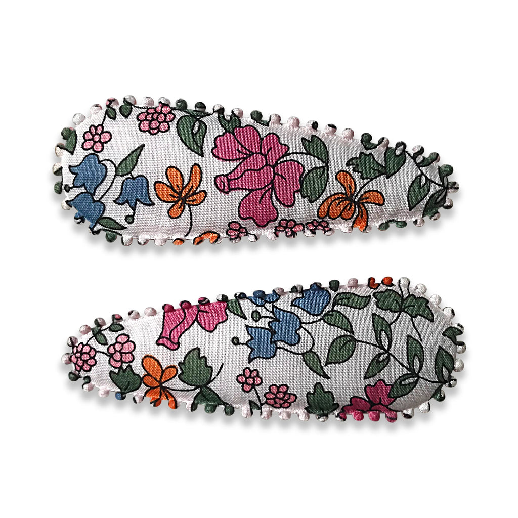 Close-up image of two Josie Joans Kimberley Hair Clips with colorful floral fabric and stitched edges.