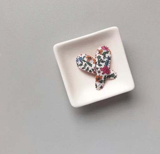 Josie Joans Kimberley Hair Clips displayed in a small white dish, showing the floral fabric design.