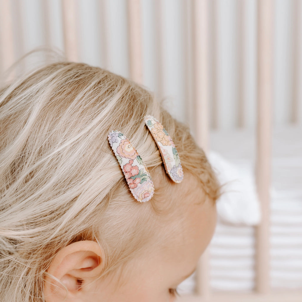 Floral hair clip on a person's head with a blurred background