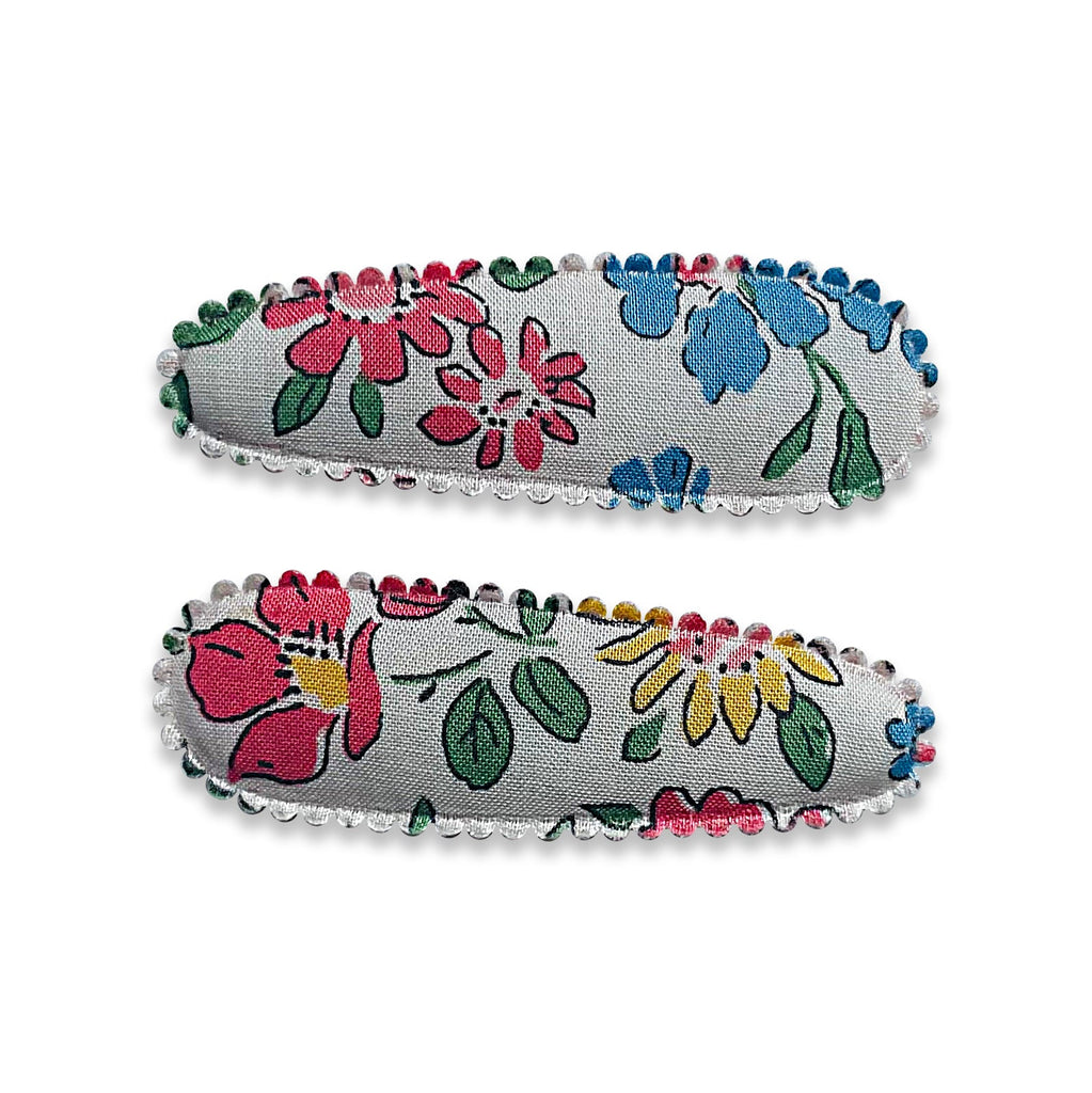 Two fabric-covered snap hair clips with a floral pattern on a gray background, sold in a pair.